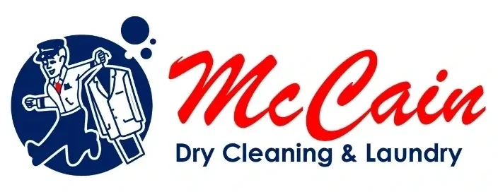 A red and blue logo for mccoy dry cleaning & laundry.